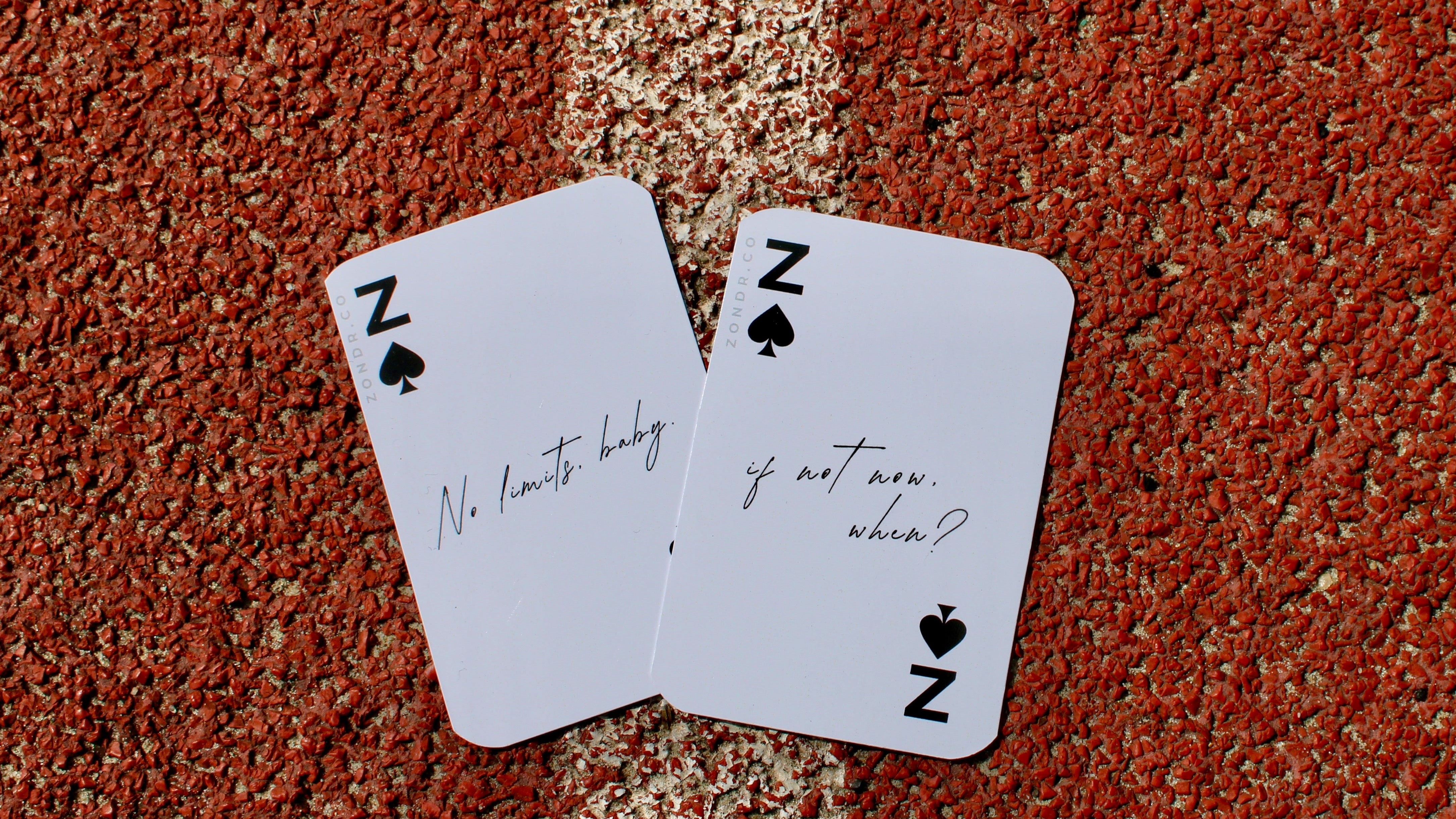 Two playing cards with text on a textured surface